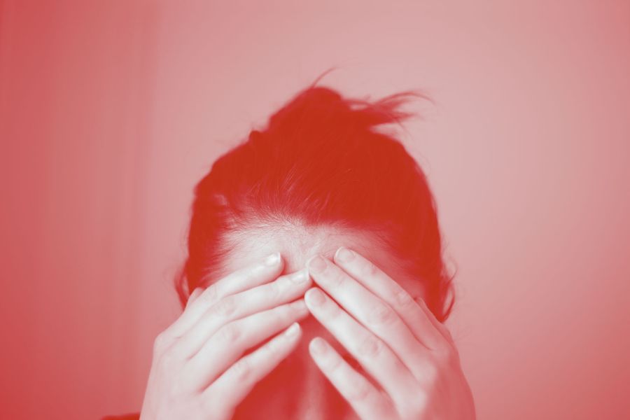 Woman touching her forehead in shame.